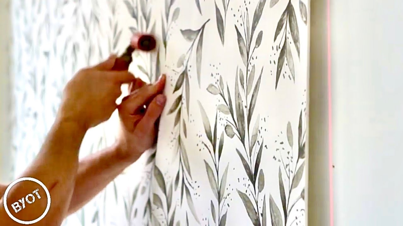 Professional installer working carefully with wallpaper material